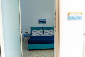 a bedroom with a bed with a blue bedspread at B&b Anna's home in Marina di Camerota