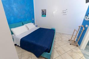 a bedroom with a bed with a blue blanket at B&b Anna's home in Marina di Camerota