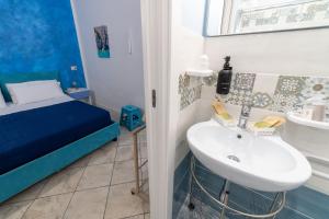 a bathroom with a sink and a bed in a room at B&b Anna's home in Marina di Camerota