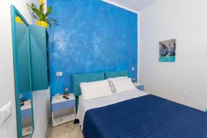 a blue bedroom with a bed and a blue wall at B&b Anna's home in Marina di Camerota