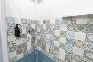 a bathroom with a shower with tiles on the wall at B&b Anna's home in Marina di Camerota