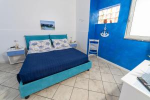 a blue bedroom with a bed and a blue wall at B&b Anna's home in Marina di Camerota