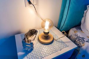 a lamp on a table next to a bed at B&b Anna's home in Marina di Camerota