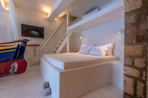 a small bedroom with a bed and a staircase at Gorgeous Apt in front of the Sea at Klima Milos in Klima