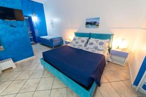 a blue bedroom with a bed and a tv at B&b Anna's home in Marina di Camerota