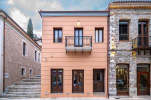 un edificio rosa con balcone di Marquesa Boutique Hotel a Nafpaktos