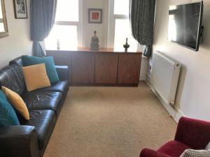 a living room with a couch and a tv at Aule Apartment in Bembridge