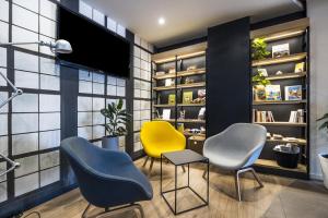 une salle d'attente avec trois chaises et une télévision dans l'établissement Campanile Perpignan Nord - Aéroport, à Rivesaltes