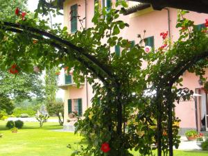 un edificio rosa con un ramo de flores en un patio en Torre dei Frati Bed & Breakfast, en Fossano