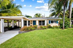 a house with palm trees and a lawn at Modern Bungalow near Wilton Drive I Pool Table in Fort Lauderdale