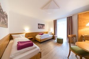 ein Hotelzimmer mit einem Bett und einem Tisch in der Unterkunft Naturparkhotel Adler in Wolfach