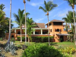 a house with palm trees in front of it at Villa Los Gorgones in Las Galeras