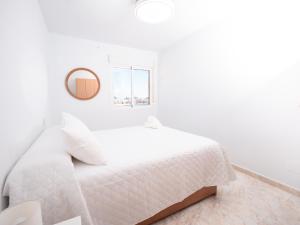 - une chambre blanche avec un lit blanc et un miroir dans l'établissement Frente al Mar con Garaje y Wifi - by Aloha Palma, à Águilas