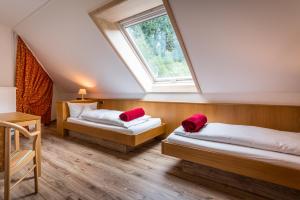 a attic room with two beds and a window at Naturparkhotel Adler in Wolfach