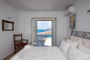 1 dormitorio con cama y vistas al océano en Mykonian Luxury Villa Victoria with Private Pool en Ftelia