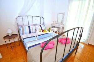 a bedroom with a bed with pink pillows on it at Villa Nirvana in Halikounas with private pool in Halikounas