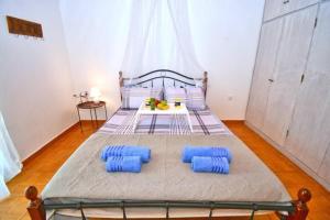 a bedroom with a bed with blue pillows on it at Villa Nirvana in Halikounas with private pool in Halikounas