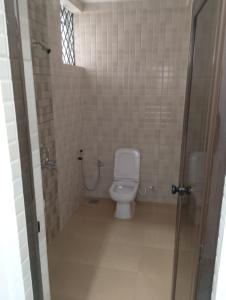 a bathroom with a white toilet in a stall at Ocean's Edge By Zac in Calangute