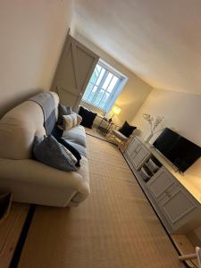 a living room with a couch and a television at Efail Fach in New Quay