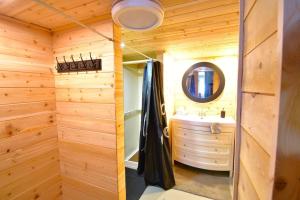 a wooden bathroom with a sink and a mirror at Chalet de l'Auberge: Lac avec Plage, SPA & Billard in Saint-Donat-de-Montcalm