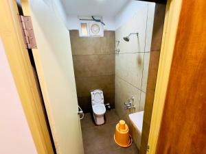 a small bathroom with a toilet and a sink at GREENS INN in Chennai