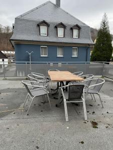 a table and chairs in front of a blue house at Große Monteurwohnung - 7 Personen - KÜCHE WIFI TV in Werdohl