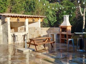 une terrasse avec un banc en bois et une cuisinière dans l'établissement Appartement d'une chambre avec piscine partagee jacuzzi et jardin clos a Avignon, à Avignon