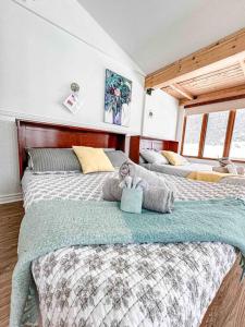1 dormitorio con 2 camas y un osito de peluche en Chalet de l'Auberge: Lac avec Plage, SPA & Billard en Saint-Donat-de-Montcalm