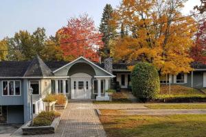 a house with a driveway in front of it at Chalet de l'Auberge: Lac avec Plage, SPA & Billard in Saint-Donat-de-Montcalm