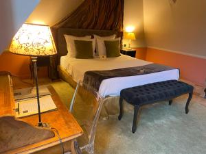 a bedroom with a bed and a table and a lamp at Le Manoir de Maucartier in Monnaie