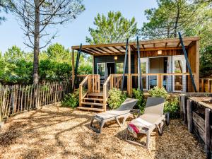 a tiny house with two chairs and a porch at Camping la Croix du Sud in Saint-Tropez