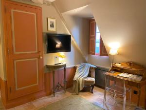 a room with a staircase with a tv and a chair at Le Manoir de Maucartier in Monnaie