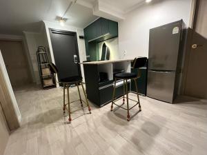 a kitchen with two bar stools and a refrigerator at Green house room 101 in Seoul