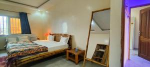 Schlafzimmer mit einem Bett und einem Spiegel in der Unterkunft Teranga Lebou in Dakar