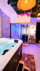 ein großes Bad mit einer Badewanne mit einem Stuhl in der Unterkunft KosyKasa SPA in Cannes