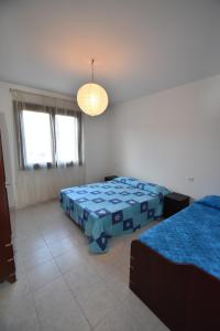 a bedroom with two beds and a light at Trilocale Lacona Mare - Zona mare con clima e posto auto in Lacona