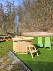 two green chairs and a hot tub in a yard at Alfapartmány in Krásná Lípa
