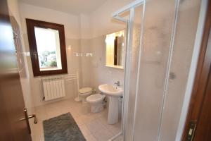 a bathroom with a toilet and a sink and a shower at Trilocale Lacona Mare - Zona mare con clima e posto auto in Lacona +22 photos