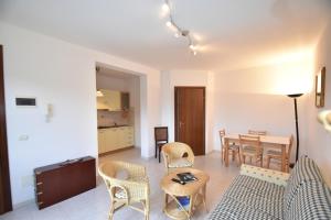 a living room with a table and chairs at Trilocale Lacona Mare - Zona mare con clima e posto auto in Lacona