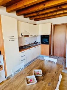 明乔河畔的瓦雷奇奥Casa Linda - Vicino al parco Sigurtà e Valeggio的配有白色橱柜和木桌的厨房