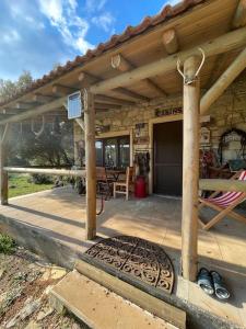 un porche de una casa con techo de madera en Saklı Doğa Çiftlik Hayatı Taş Ev en Urla
