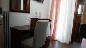 Cette chambre dispose d'une fenêtre et d'un bureau avec une chaise. dans l'établissement Rooms Batalogianni, à Kalambaka