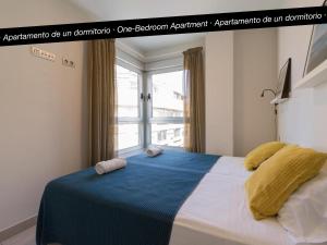 ラスパルマス・デ・グランカナリアにあるTusity Yeah Apartmentsのベッドルーム1室(枕2つ、窓付)