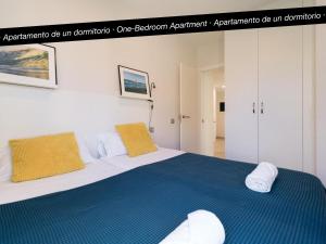 ラスパルマス・デ・グランカナリアにあるTusity Yeah Apartmentsのベッドルーム1室(ベッド1台、タオル2枚付)