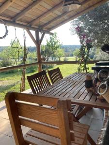 una mesa de madera y sillas sentadas en un porche en Saklı Doğa Çiftlik Hayatı Taş Ev en Urla