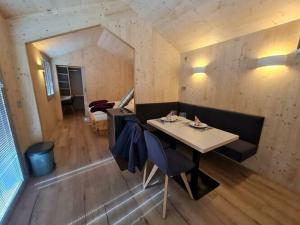 ein Esszimmer mit einem Tisch und Stühlen in einem Zimmer in der Unterkunft Ferienhaus Woodcube Großkirchheim in Großkirchheim