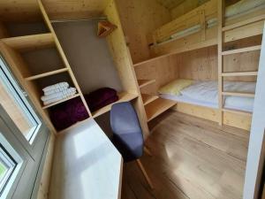 Zimmer mit 2 Etagenbetten und einem Stuhl in der Unterkunft Ferienhaus Woodcube Großkirchheim in Großkirchheim