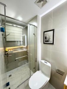 y baño con ducha, aseo y cabina de ducha de cristal. en Luxury Suite near Clark International Airport en Ángeles