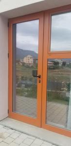 een oranje deur met uitzicht op een gebouw bij J & A in Tirana