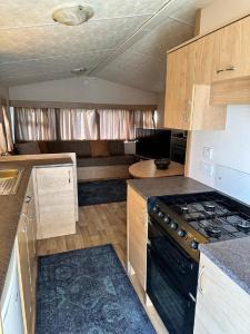 an rv kitchen with a stove and a couch at 6 Berth Caravan At Dovercourt Holiday Park In Essex Ref 44006s in Great Oakley